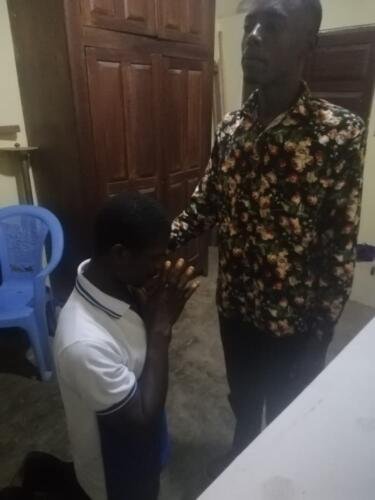 Student Emmanuel praying for the sick 